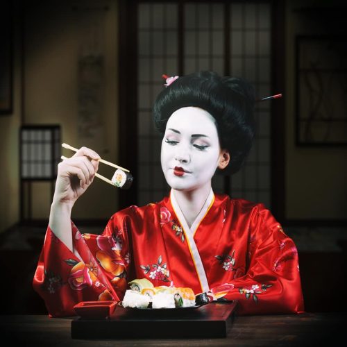 Woman in geisha makeup eating sushi